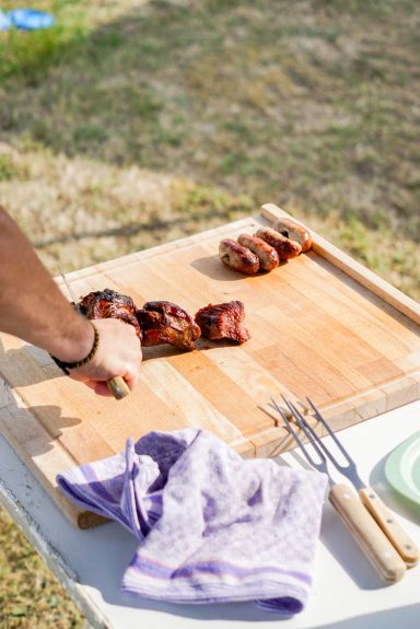 Person schneidet Fleisch, dass eben frisch vom Grill kam