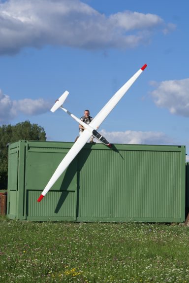 Mann hält Segler mit sehr großer Spannweite vom Dach, um die Länge der Tragflächen zu zeigen.