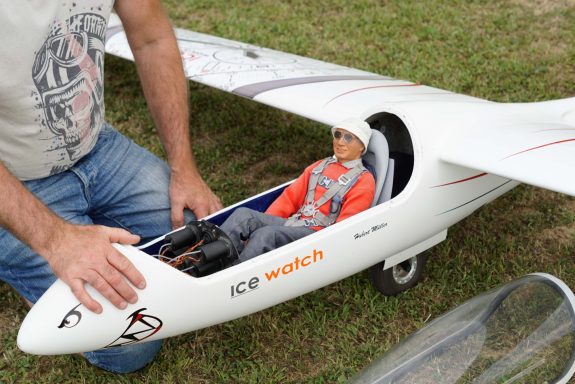 Eine Puppe sitzt im Cockpit eines Modellflugzeugs